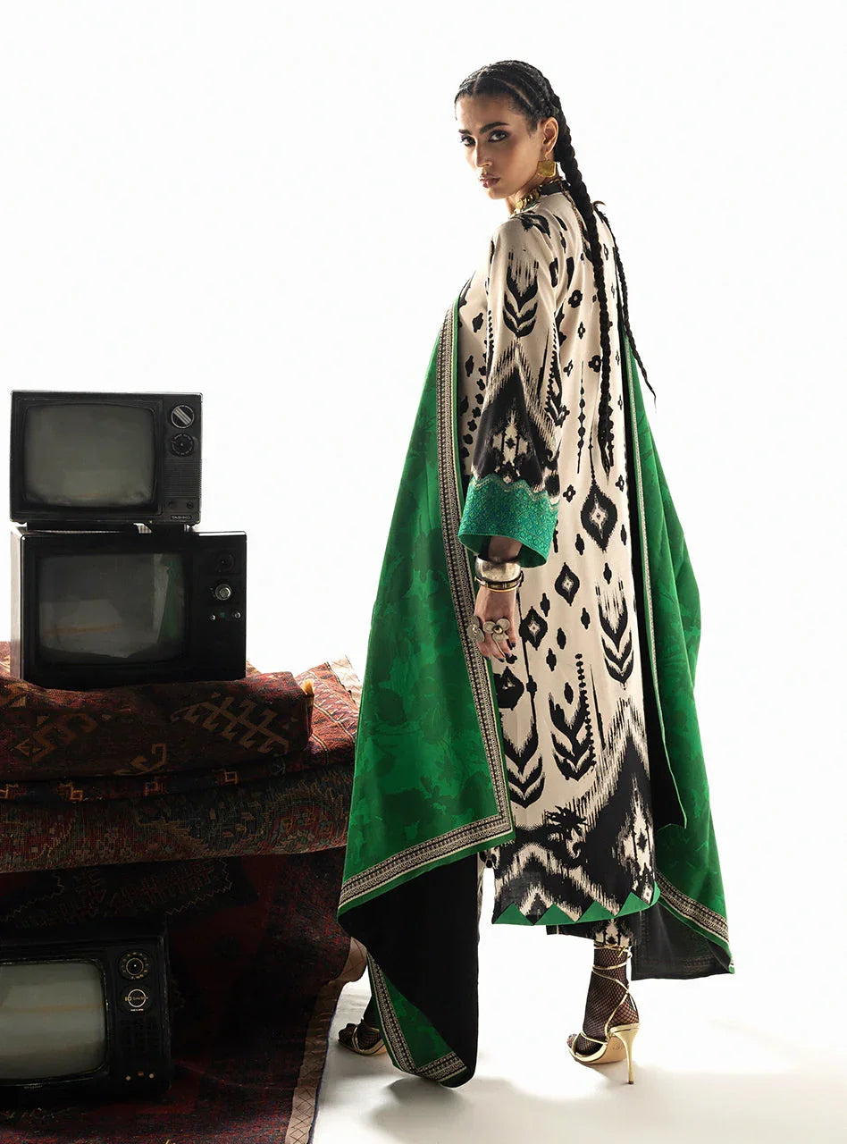 Woman in elegant black and cream printed kurta with green dupatta, styled with gold heels and vintage TVs
