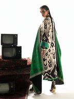 Woman in elegant black and cream printed kurta with green dupatta, styled with gold heels and vintage TVs