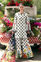 Woman in white polka dot floral print palazzo suit with matching dupatta, standing by a flower-decked vintage car.