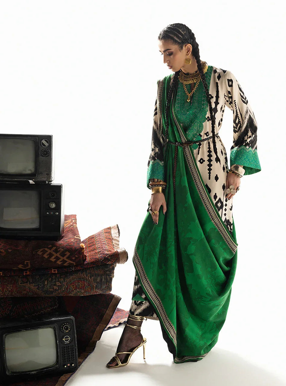 Woman in green and cream printed saree with gold jewelry, styled with vintage TVs and patterned rugs