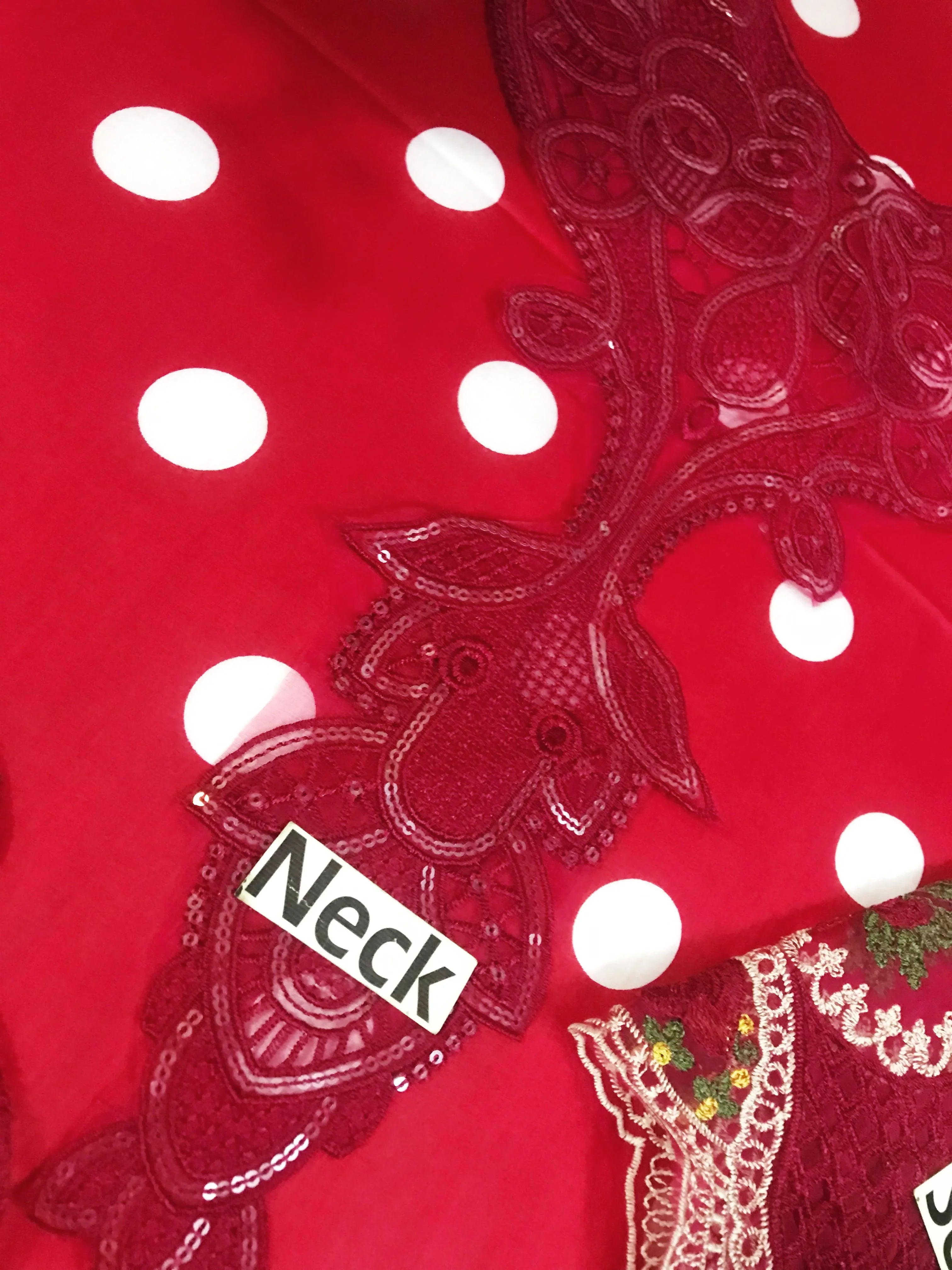 Red polka dot dress with lace neck detailing and sequin embellishments