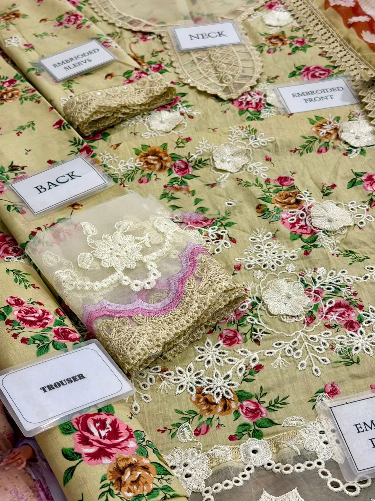 Floral embroidered dress with lace details, labeled sections for neck, sleeves, front, back, and trouser