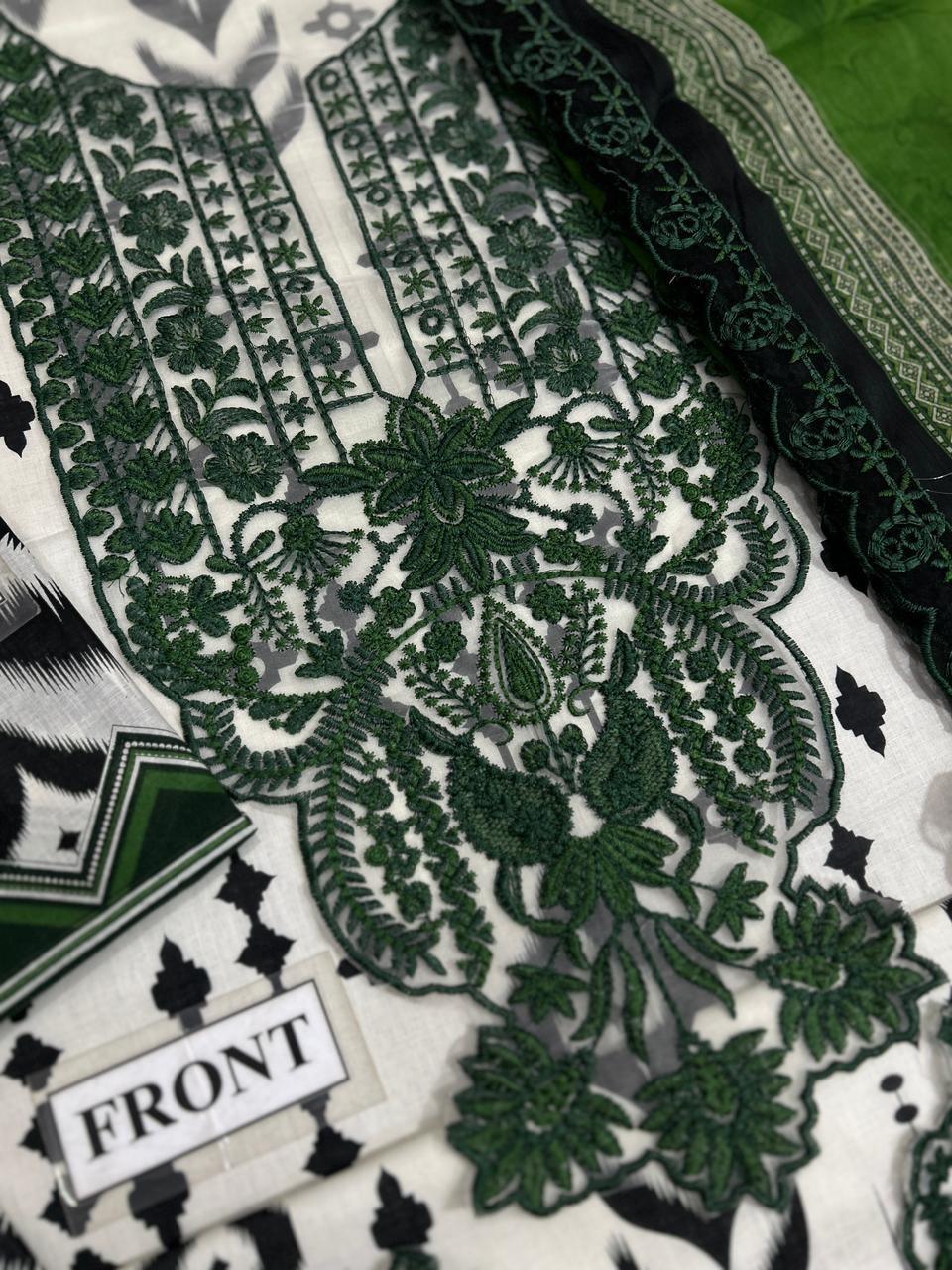 Green floral embroidery on white fabric, detailed front panel with black accents and lace trim