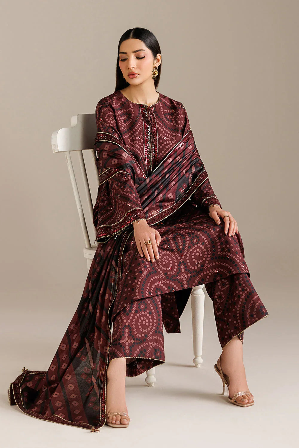 Elegant maroon printed kurta with geometric patterns, paired with matching palazzo and dupatta, styled for formal occasions.