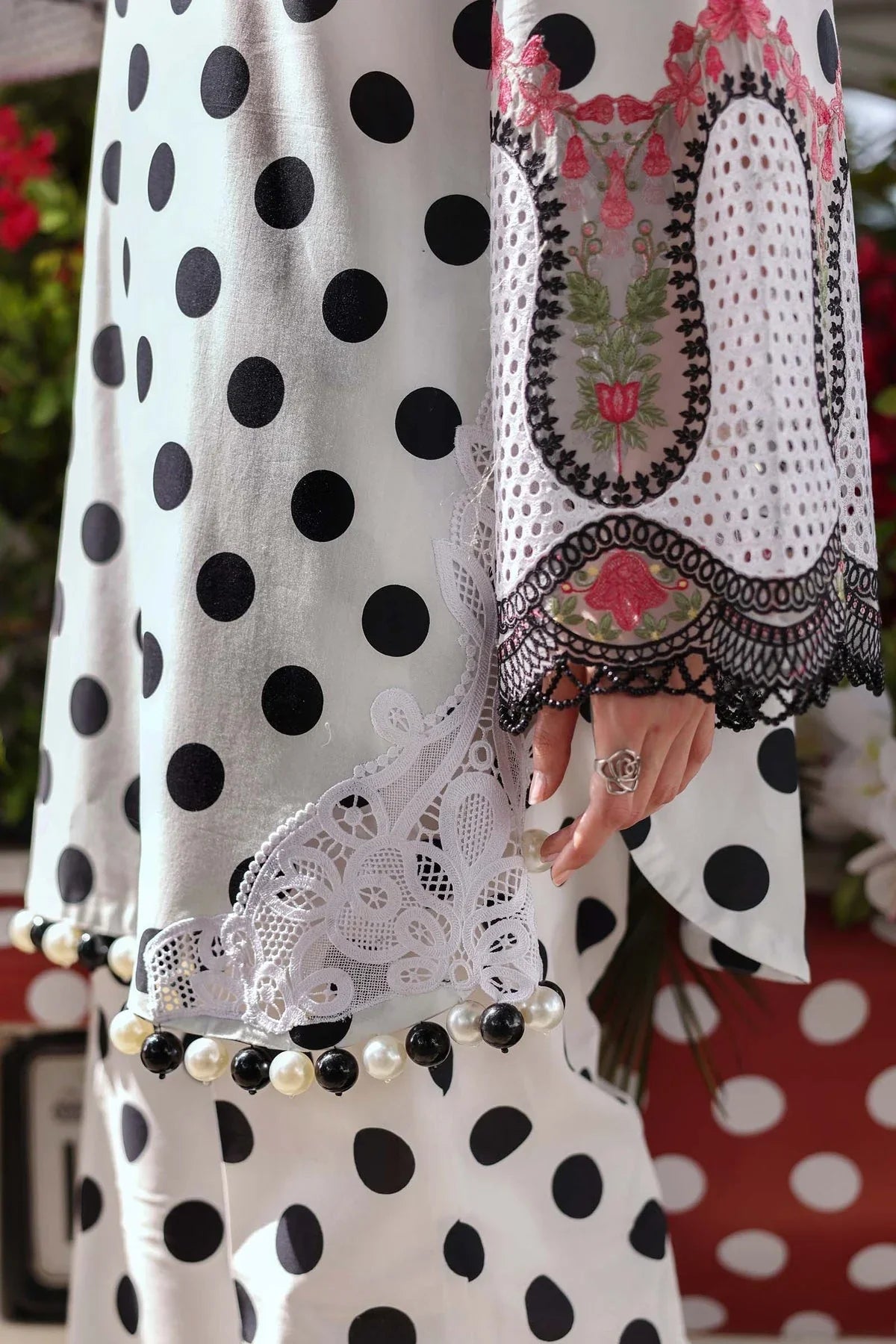 White polka dot dress with lace trim, floral embroidery, and pearl bead detailing on sleeves